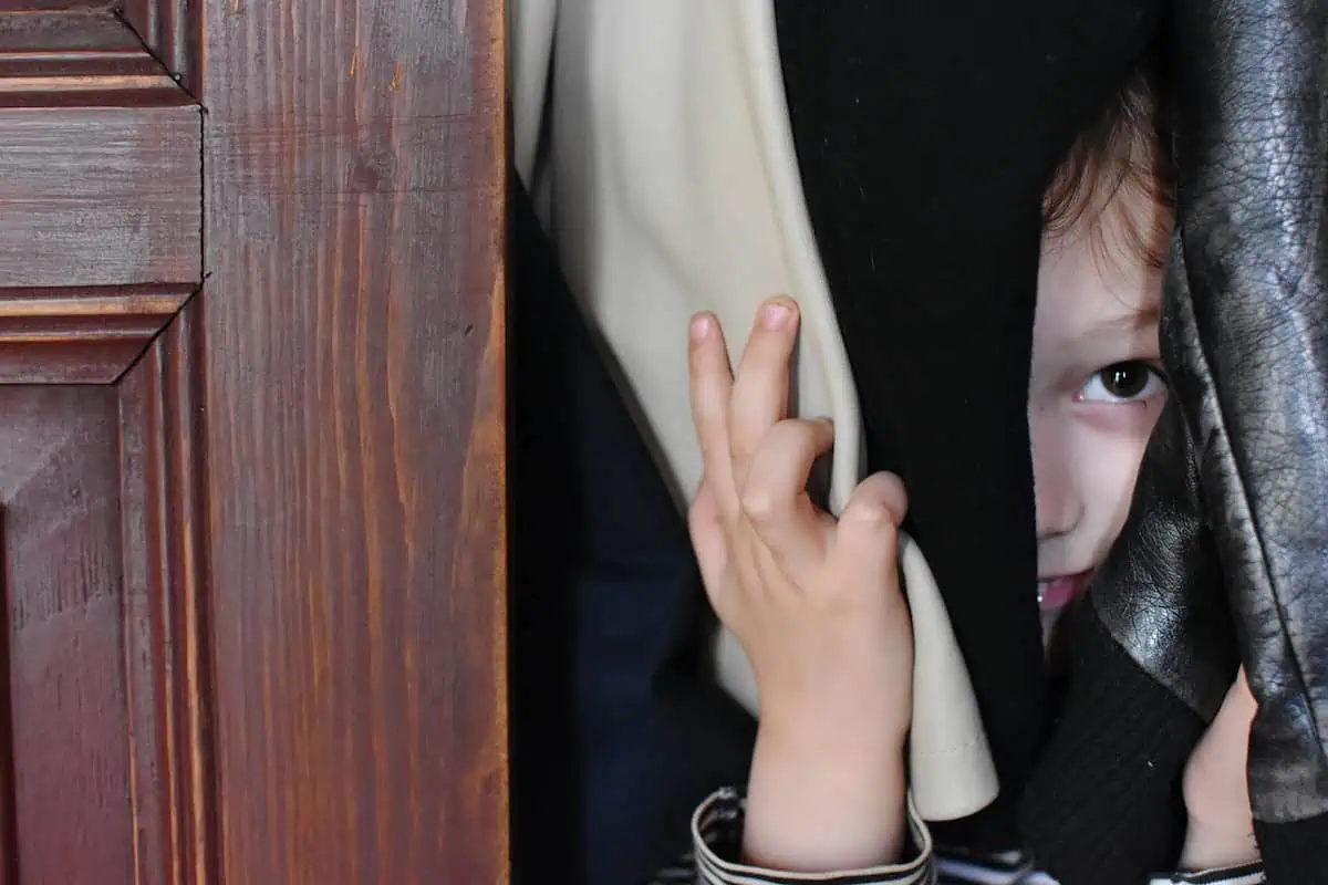 Niño escondiéndose en un armario.
